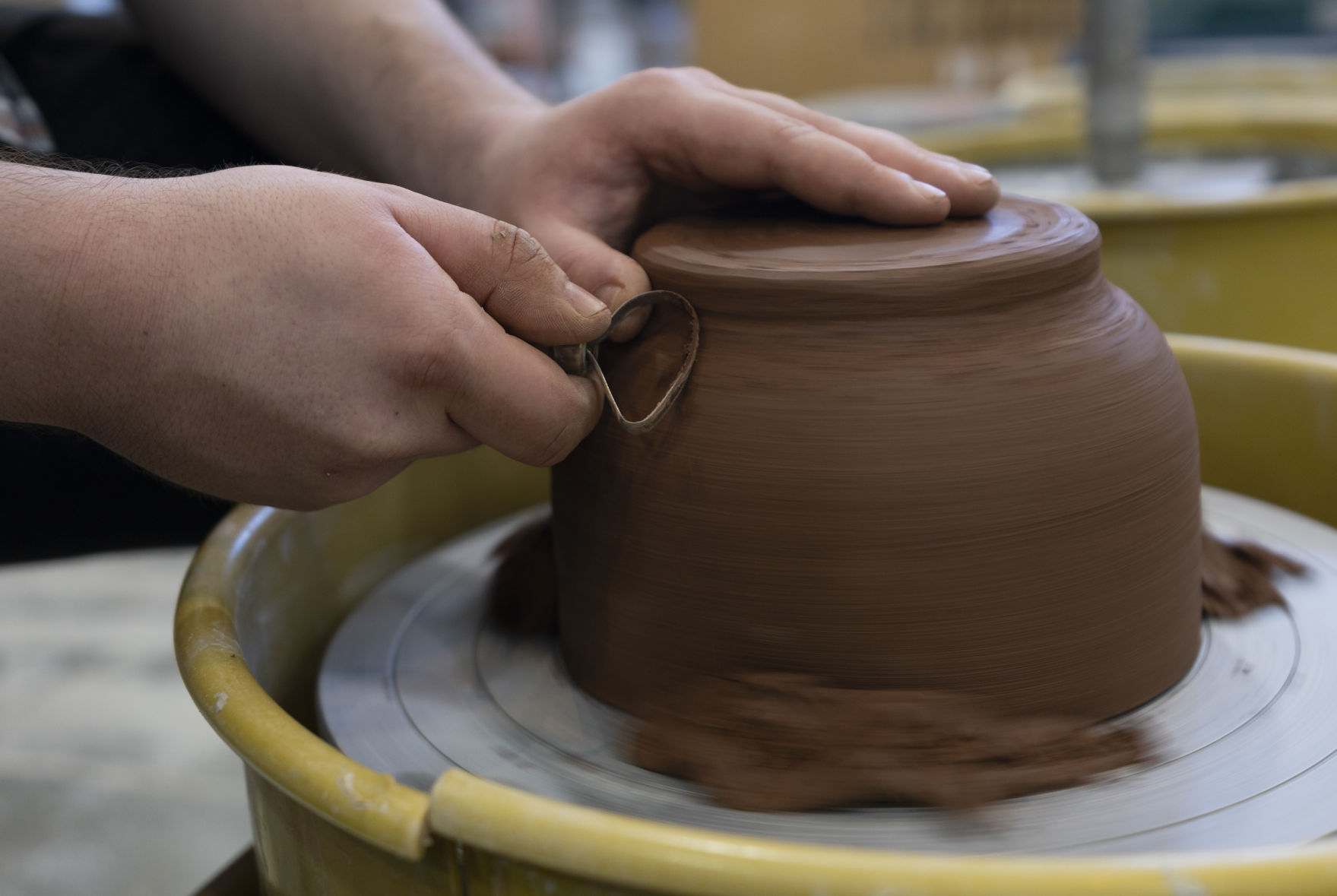 Throwing clay on the wheel